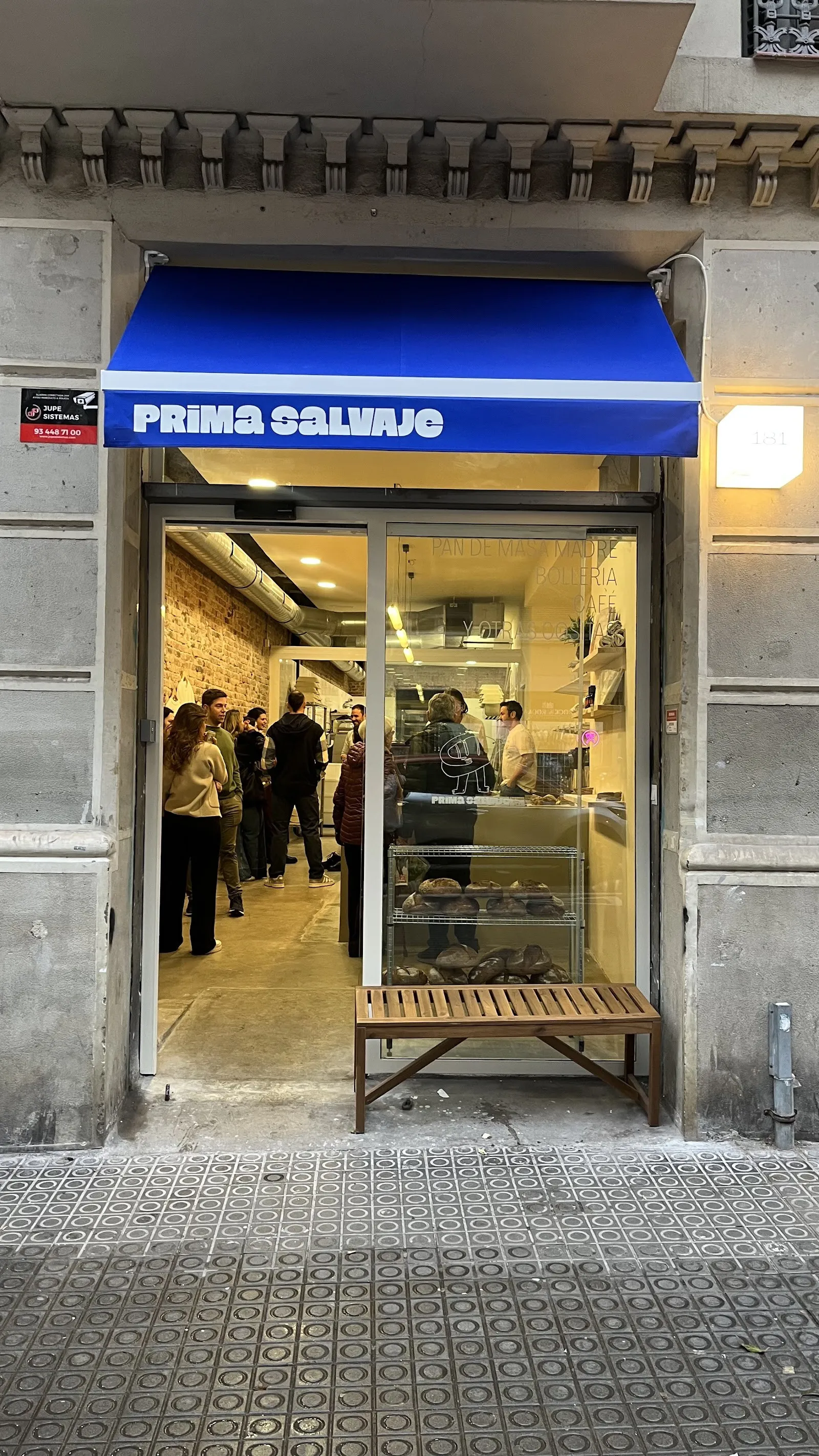 La entrada de Prima Salvaje en Carrer de Girona, con su toldo azul